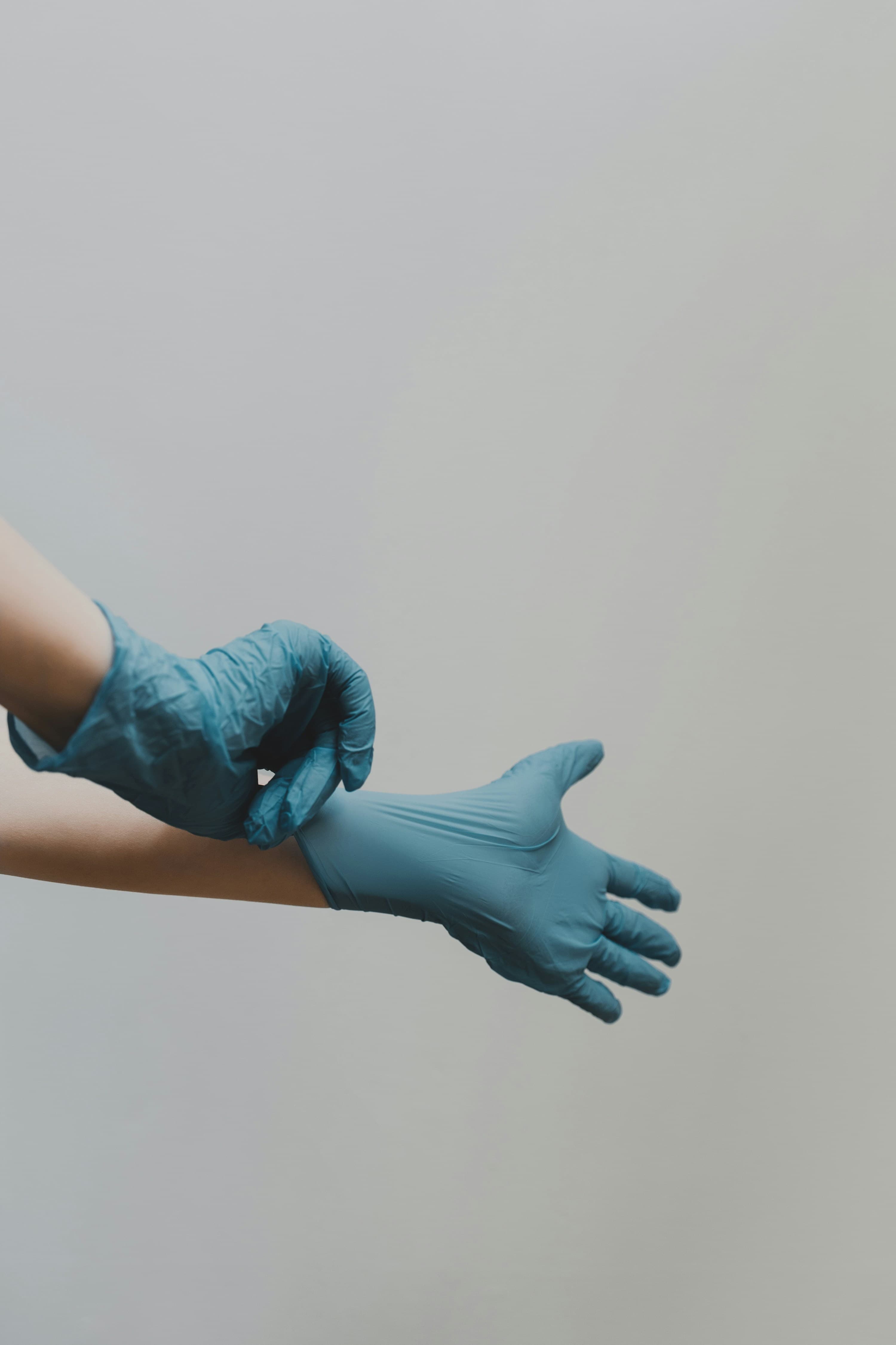 Clinician pulling on sterile medical gloves